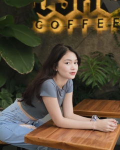 "wanita sedang duduk di cafe"